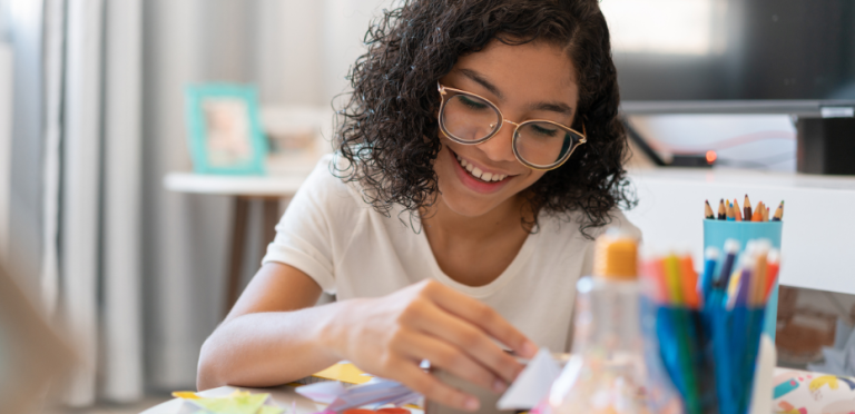 Photograph of a young girl smiling doing an art activity
