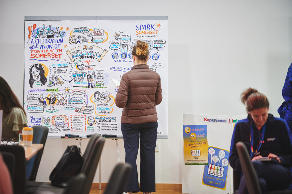 Photograph of an illustrator at work, capturing the day in an illustration.