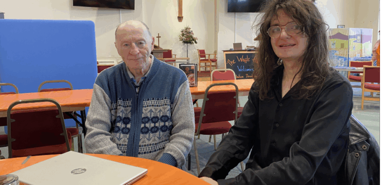 Client Bob, sat with Digital Champion volunteer Nate at a table with a laptop