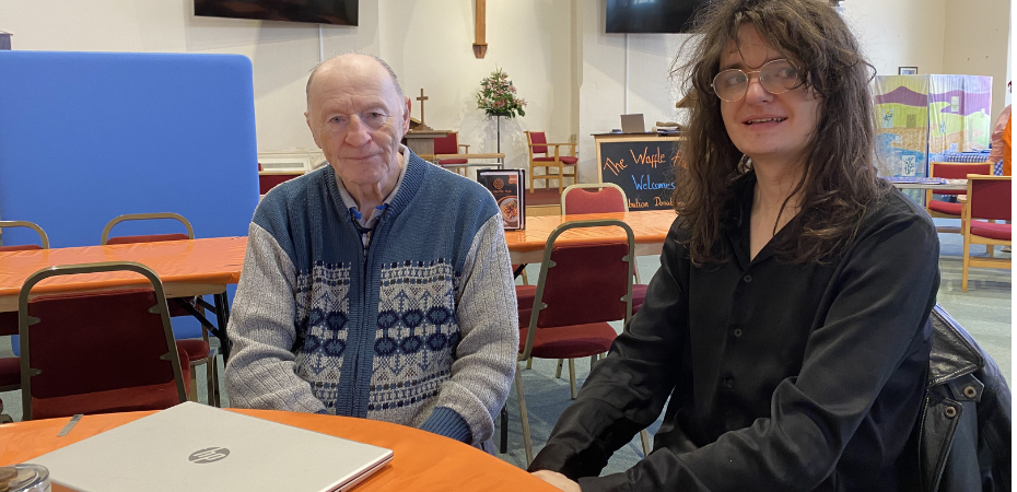 Client Bob, sat with Digital Champion volunteer Nate at a table with a laptop