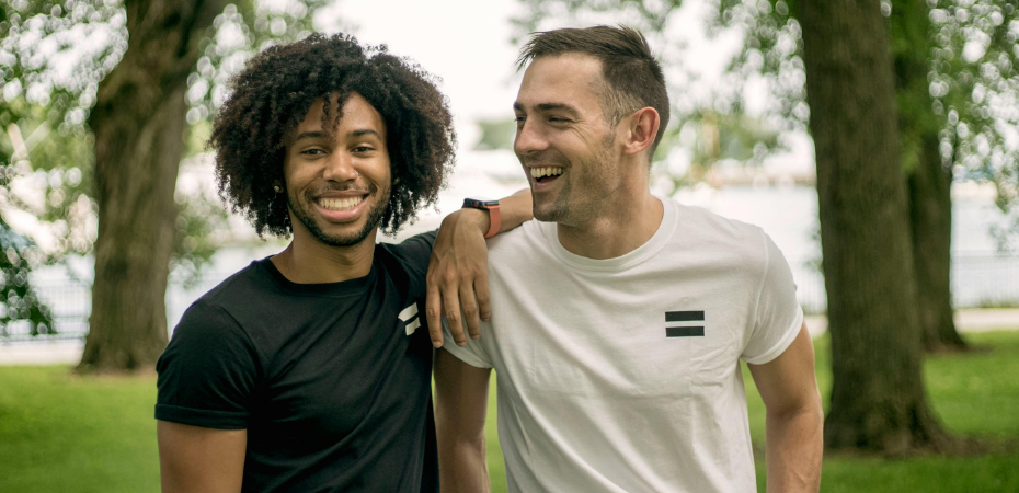 photograph of two young men smiling at the camera in an outdoor setting