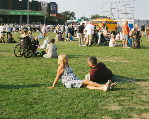 An image of a crowd of people at an outdoor event; some are in wheelchairs or have crutches