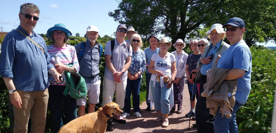 A photograph of a group of walkers who have stopped for a photograph along the canal path on a sunny, blue sky day