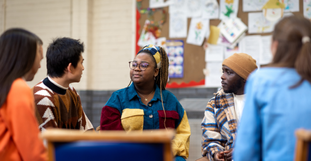 Photograph of a diverse group of people in conserversation at a table