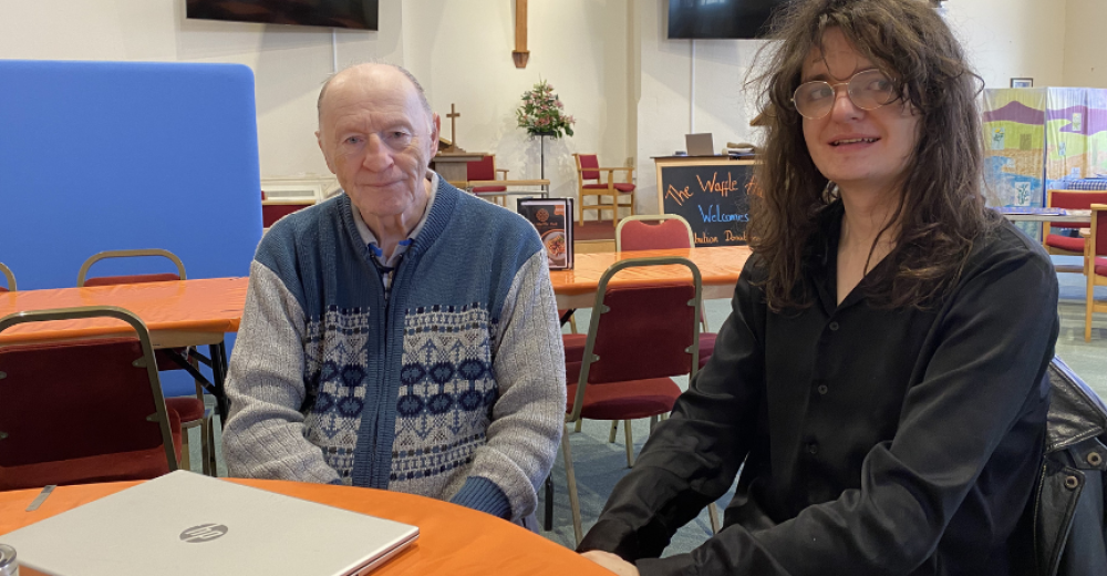 Client Bob, sat with Digital Champion volunteer Nate at a table with a laptop