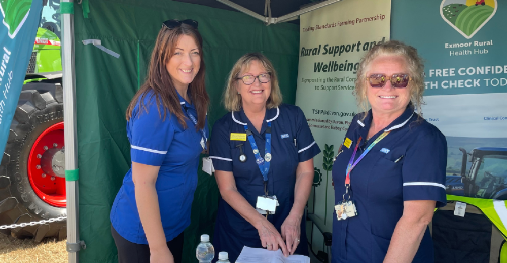A photo of three of the nurses from the Exmoor Rural Health Hub, stood together at a promotional stall for the hub. They are smiling at the camera.