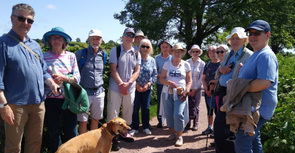 A photograph of a group of walkers who have stopped for a photograph along the canal path on a sunny, blue sky day