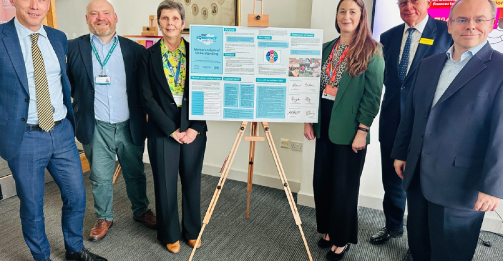 Team of people standing next to a flip chart displaying a large copy of the Memorandum of Understanding