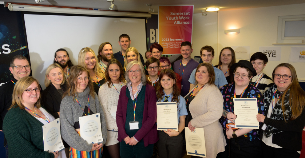 Photo of newly qualified learners with their certificates at the Somerset Youth Work Alliance event.